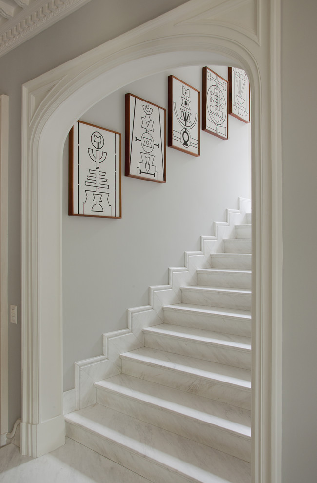 Foto de escalera recta clásica con escalones de mármol y contrahuellas de mármol