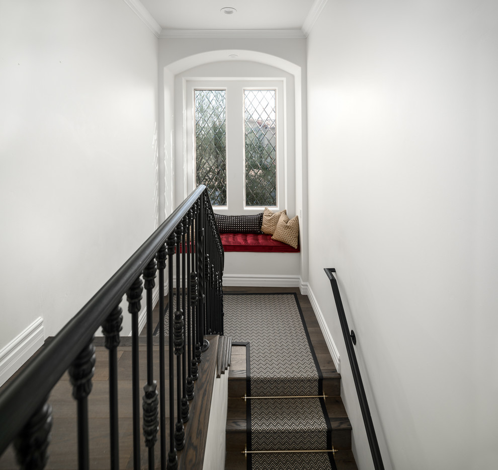 Ejemplo de escalera recta romántica extra grande con escalones enmoquetados, contrahuellas de madera y barandilla de metal