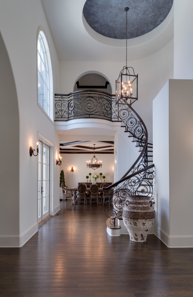 This is an example of a rustic metal curved staircase in Charlotte with wood risers.