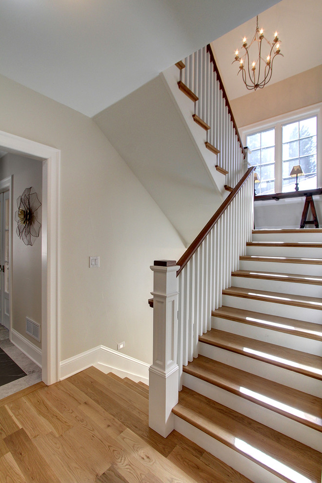 Example of a large transitional wooden u-shaped wood railing staircase design in Denver with painted risers