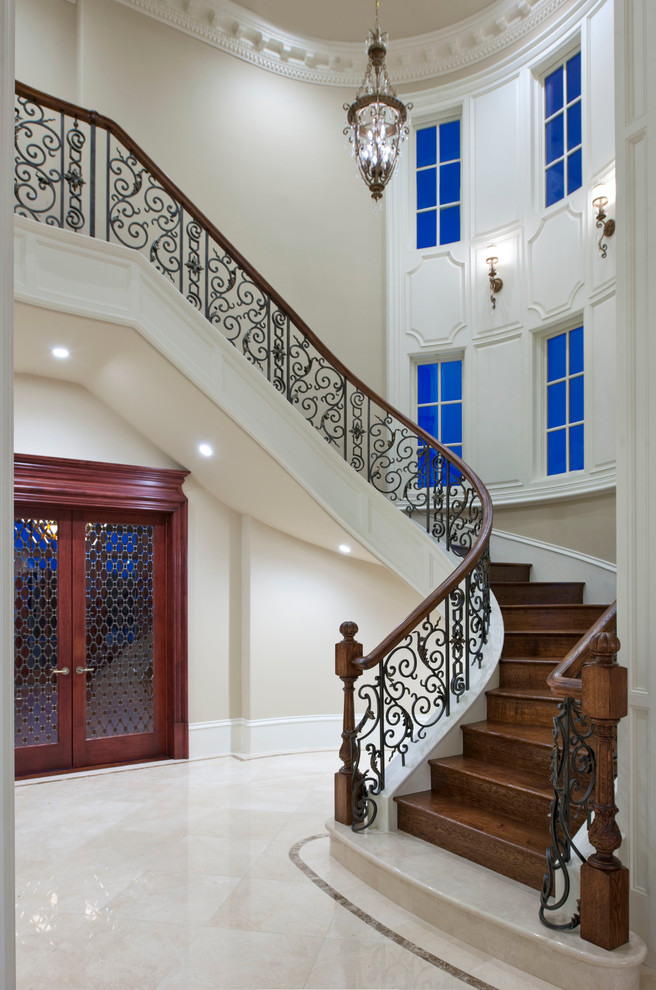 Exemple d'un très grand escalier courbe chic avec des marches en bois et des contremarches en bois.