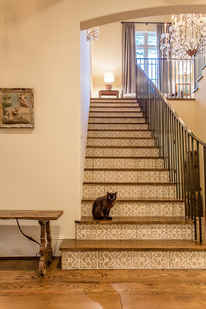 На фото: большая п-образная лестница в средиземноморском стиле с деревянными ступенями и подступенками из плитки