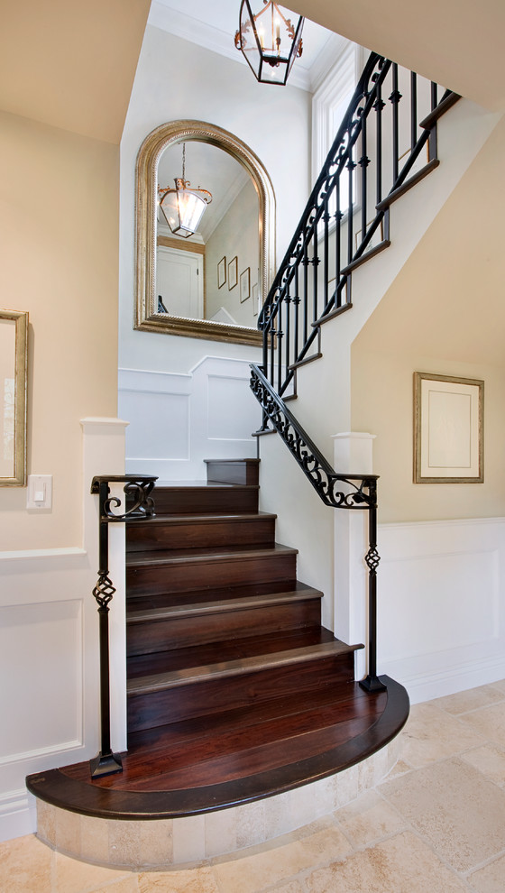 Design ideas for a mediterranean wood u-shaped staircase in Orange County with wood risers.