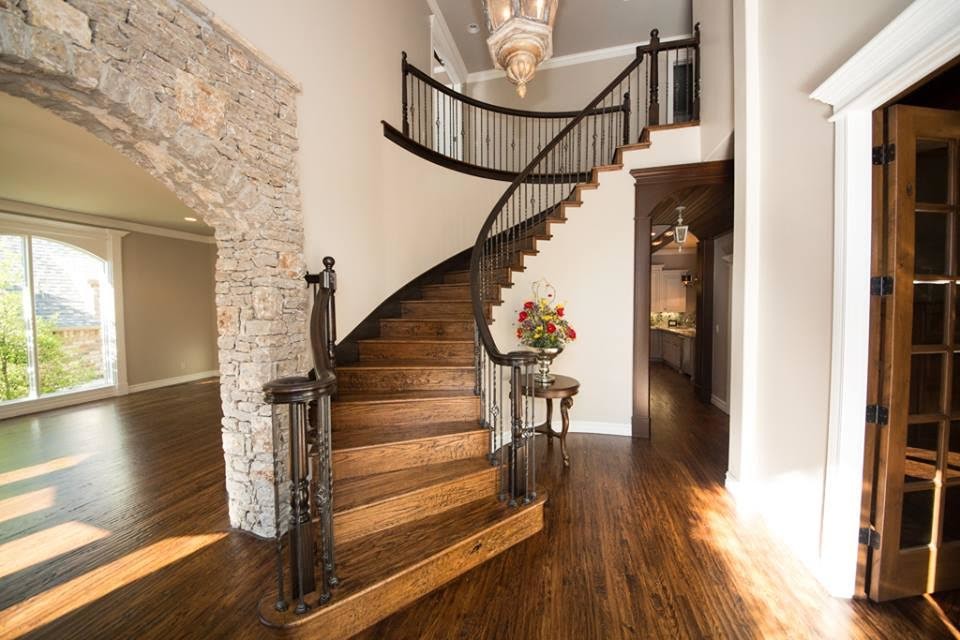 Diseño de escalera curva clásica de tamaño medio con escalones de madera, contrahuellas de madera y barandilla de varios materiales