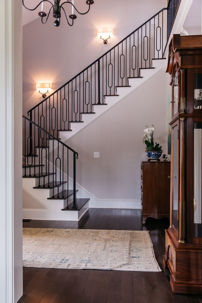 Стильный дизайн: лестница в классическом стиле с крашенными деревянными подступенками и металлическими перилами - последний тренд