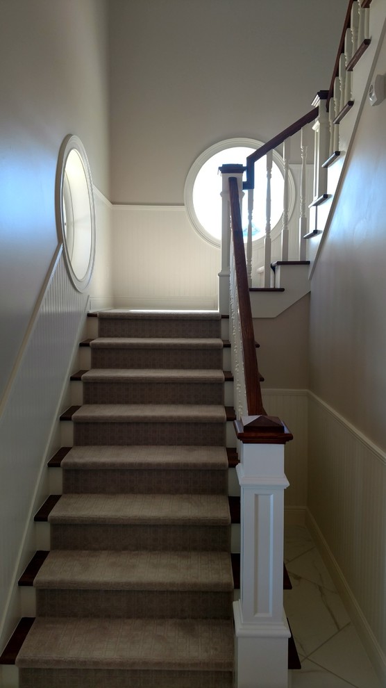 Пример оригинального дизайна: угловая лестница среднего размера в классическом стиле с ступенями с ковровым покрытием, ковровыми подступенками и деревянными перилами