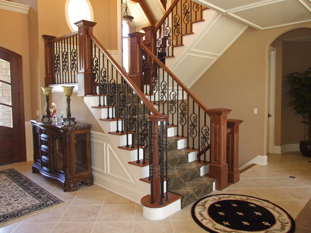 Стильный дизайн: огромная угловая лестница в стиле неоклассика (современная классика) с ступенями с ковровым покрытием и ковровыми подступенками - последний тренд