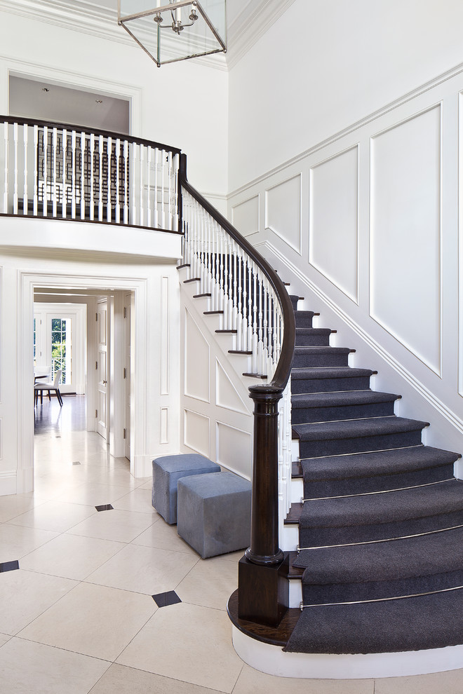 Стильный дизайн: изогнутая лестница среднего размера в стиле неоклассика (современная классика) с деревянными перилами, деревянными ступенями и крашенными деревянными подступенками - последний тренд