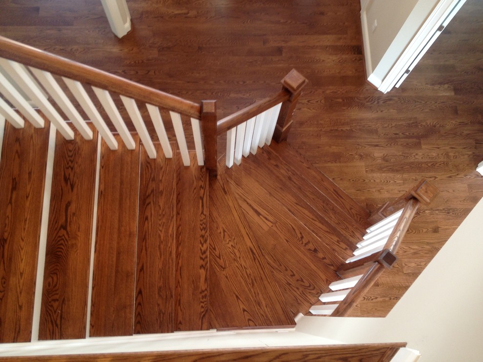 Ejemplo de escalera curva de estilo americano con escalones de madera y contrahuellas de madera pintada