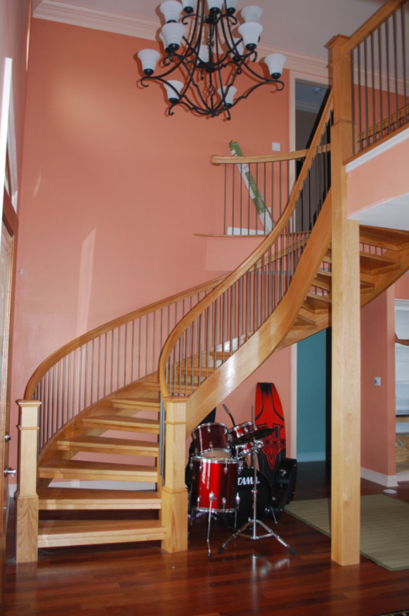 Diseño de escalera curva de estilo americano de tamaño medio con escalones de madera y contrahuellas de madera