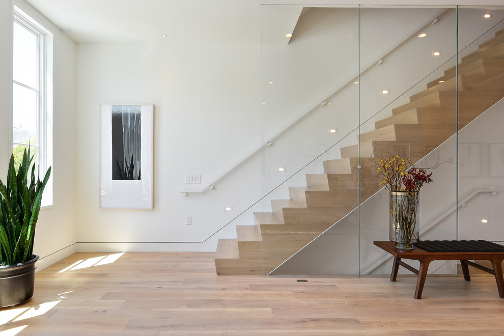 Modelo de escalera recta contemporánea con escalones de madera, contrahuellas de madera y barandilla de vidrio
