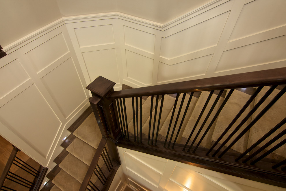 Ejemplo de escalera curva actual de tamaño medio con barandilla de madera y escalones de madera