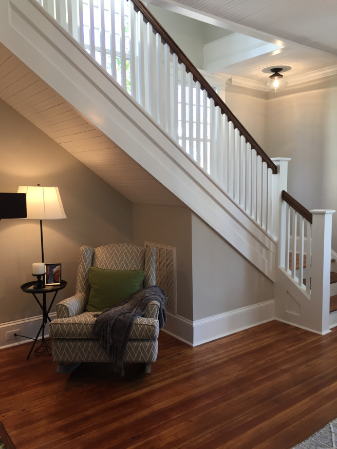 Imagen de escalera en L de estilo americano de tamaño medio con escalones de madera, contrahuellas de madera pintada y barandilla de madera