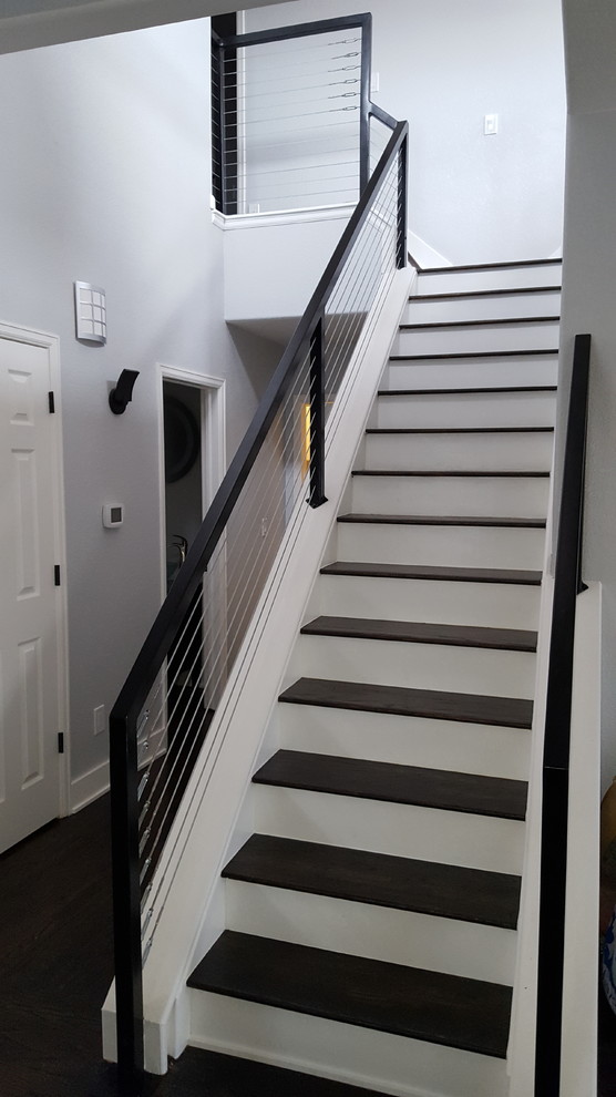 Imagen de escalera recta minimalista de tamaño medio con escalones de madera, contrahuellas de madera pintada y barandilla de cable