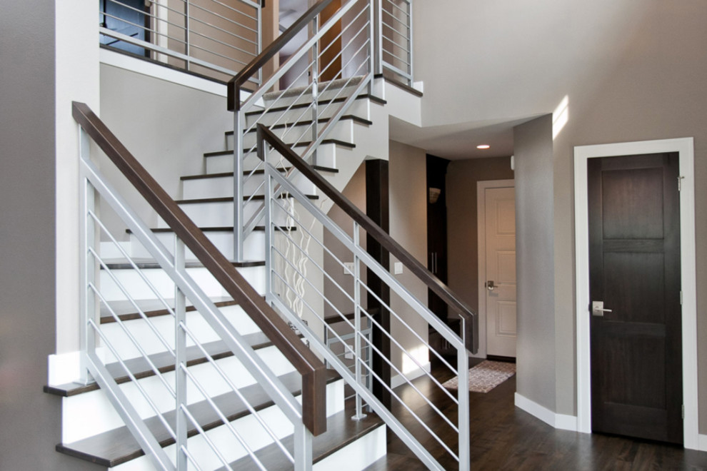 Foto de escalera en L clásica renovada de tamaño medio con escalones de madera, contrahuellas de madera pintada y barandilla de varios materiales