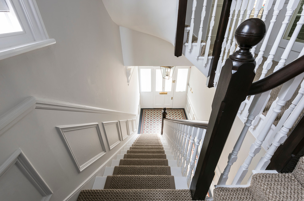 ロンドンにあるラグジュアリーな広いトランジショナルスタイルのおしゃれな折り返し階段の写真