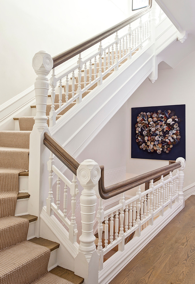 This is an example of a large traditional wood l-shaped staircase in Chicago with painted wood risers.