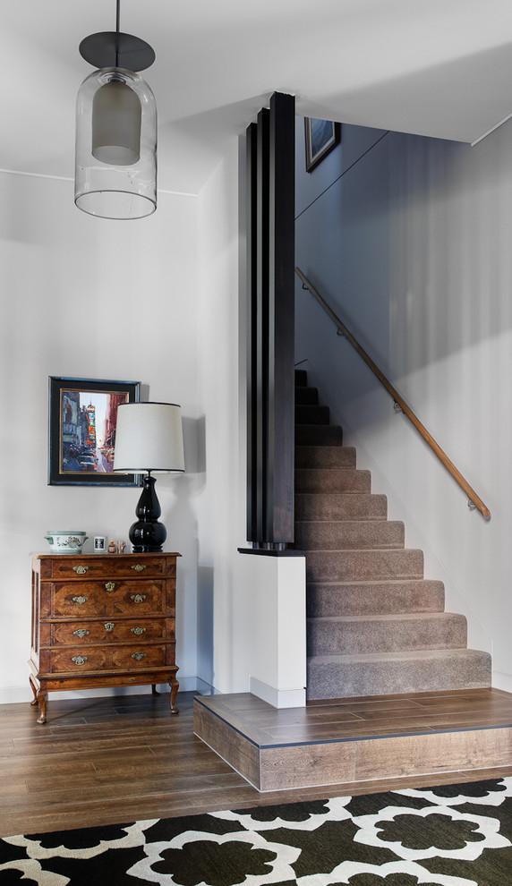 Idée de décoration pour un escalier droit design de taille moyenne avec des marches en moquette, des contremarches en moquette, un garde-corps en bois et éclairage.
