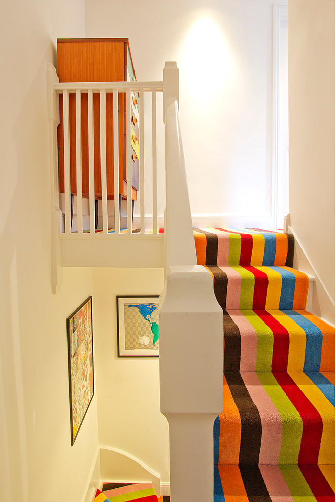 Photo of a modern painted wood straight staircase in London with painted wood risers.