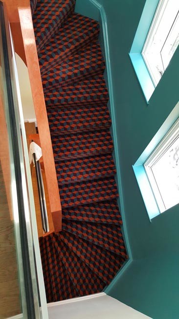 Источник вдохновения для домашнего уюта: изогнутая лестница среднего размера в стиле модернизм с ступенями с ковровым покрытием, ковровыми подступенками и перилами из смешанных материалов