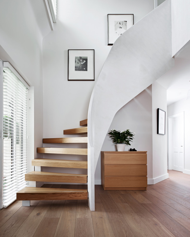 Diseño de escalera curva contemporánea grande sin contrahuella con escalones de madera