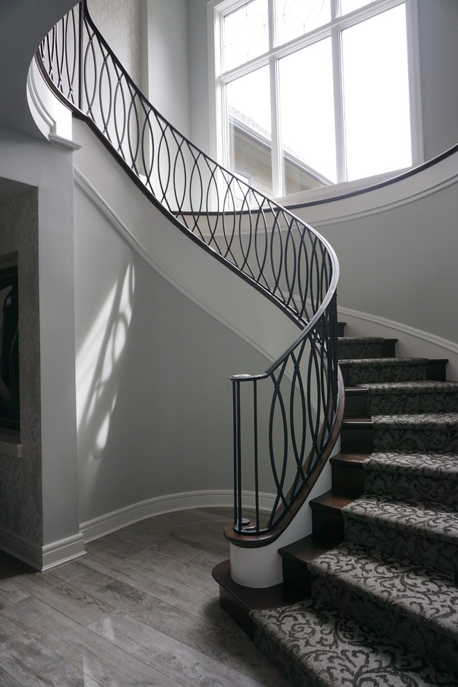 На фото: большая винтовая металлическая лестница в стиле ретро с ступенями с ковровым покрытием