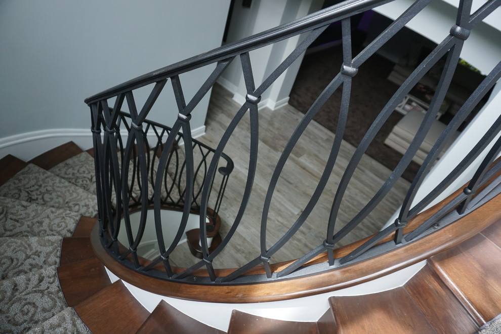 На фото: большая винтовая металлическая лестница в стиле ретро с ступенями с ковровым покрытием с