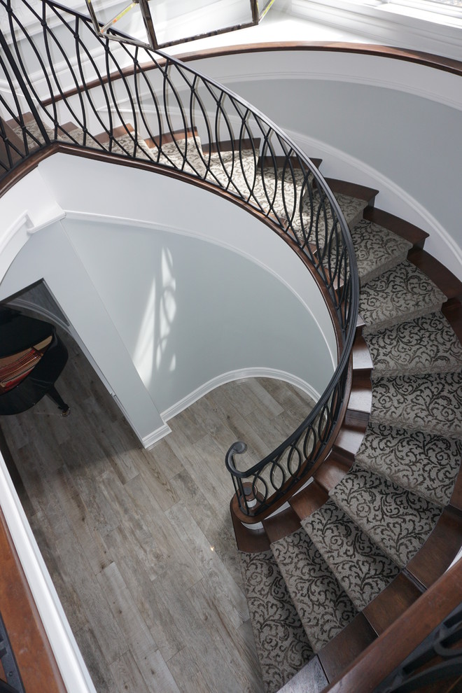 Источник вдохновения для домашнего уюта: большая винтовая металлическая лестница в стиле ретро с ступенями с ковровым покрытием