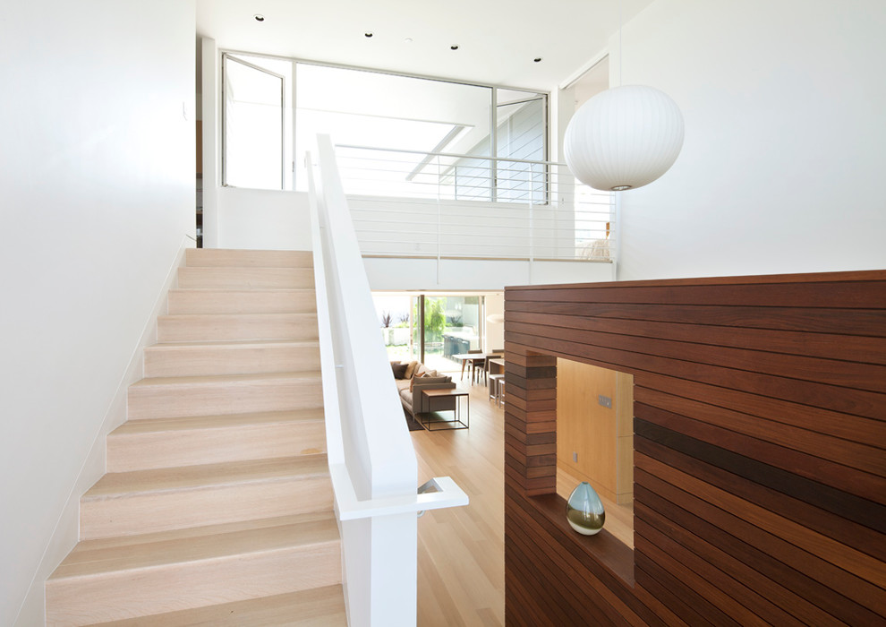 Inspiration for a small contemporary wood u-shaped metal railing staircase in Los Angeles with wood risers.