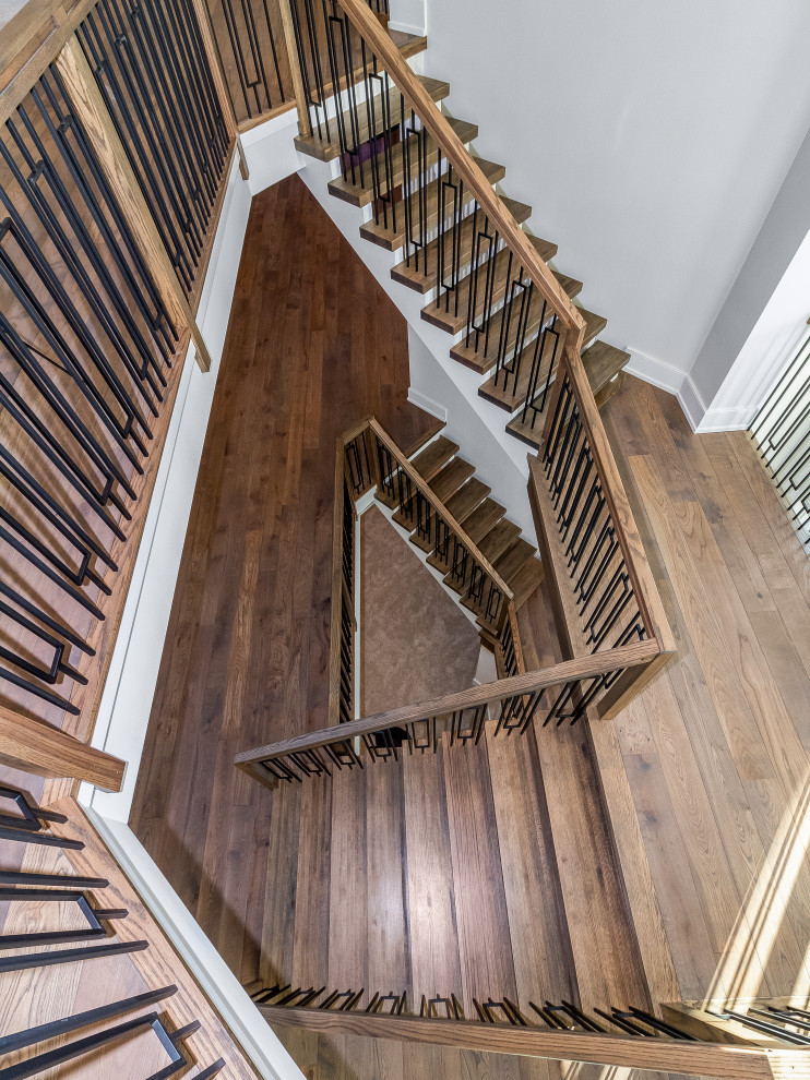 シカゴにあるコンテンポラリースタイルのおしゃれな折り返し階段 (木材の手すり) の写真