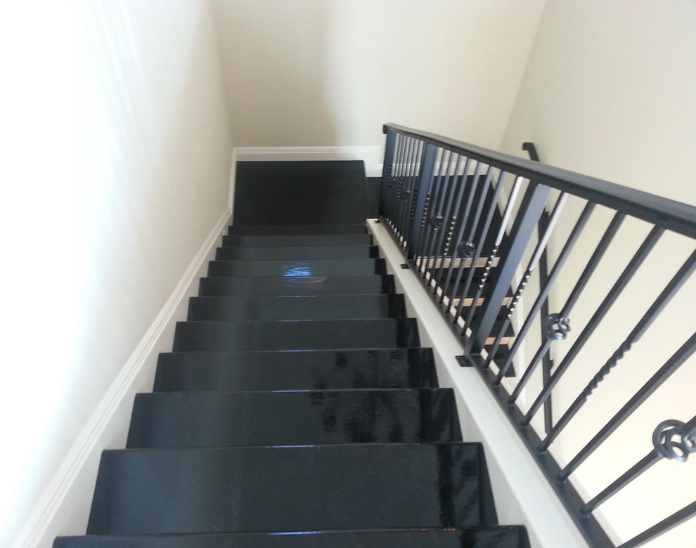 Cette photo montre un grand escalier peint en U avec des marches en bois peint.