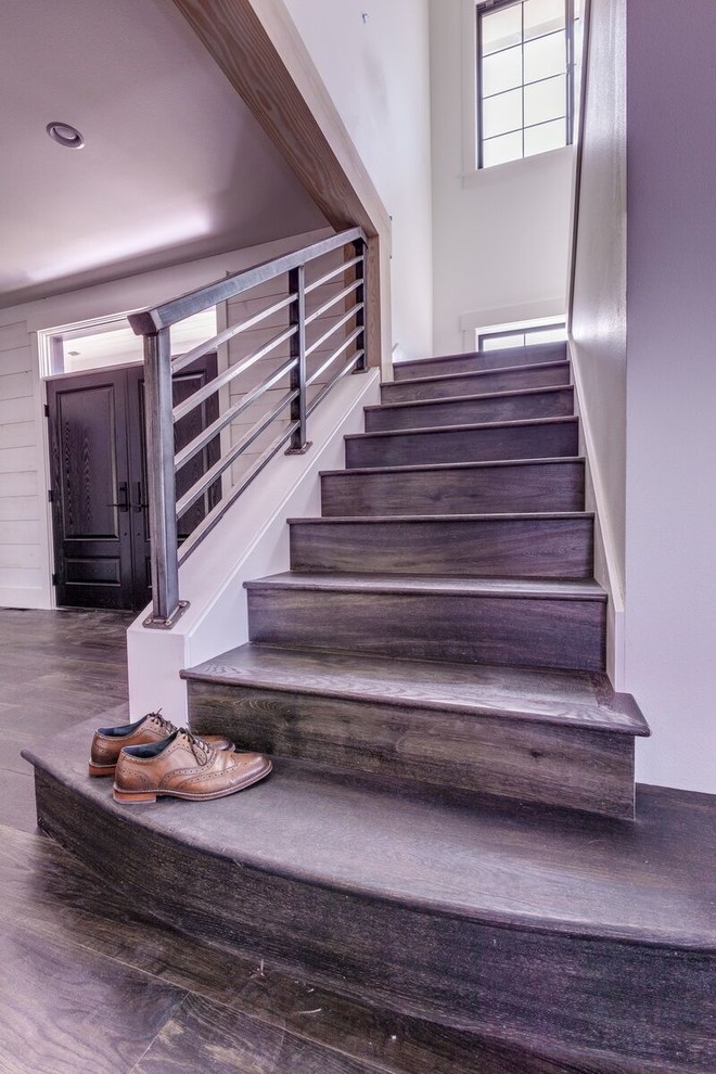 На фото: угловая деревянная лестница среднего размера в стиле лофт с деревянными ступенями и металлическими перилами