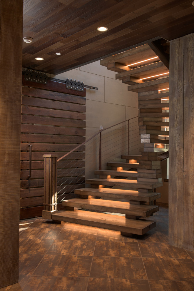 Idée de décoration pour un escalier sans contremarche hélicoïdal chalet de taille moyenne avec des marches en bois et un garde-corps en câble.