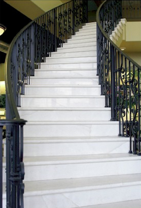 Свежая идея для дизайна: большая изогнутая лестница с ступенями из плитки и подступенками из плитки - отличное фото интерьера