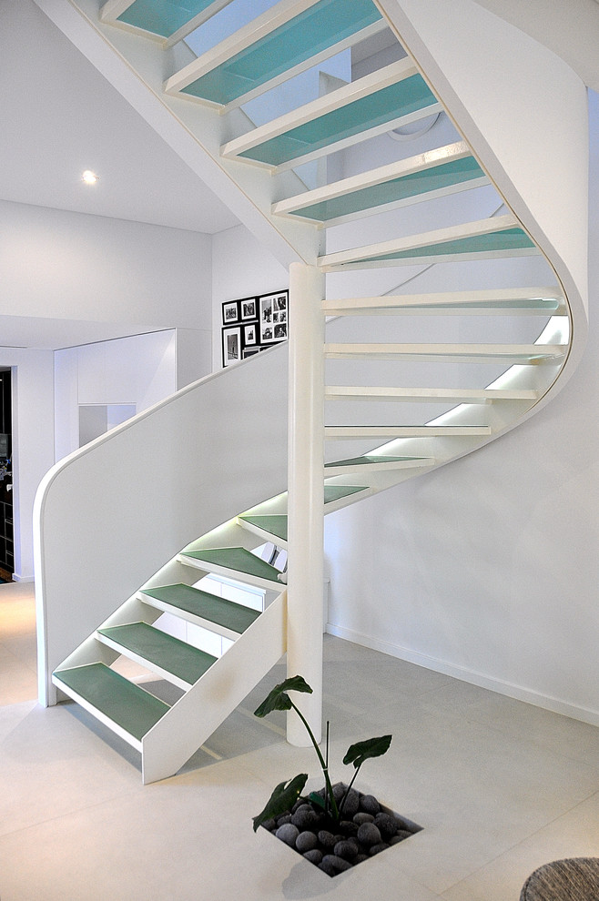 Idée de décoration pour un escalier sans contremarche courbe design avec des marches en verre.