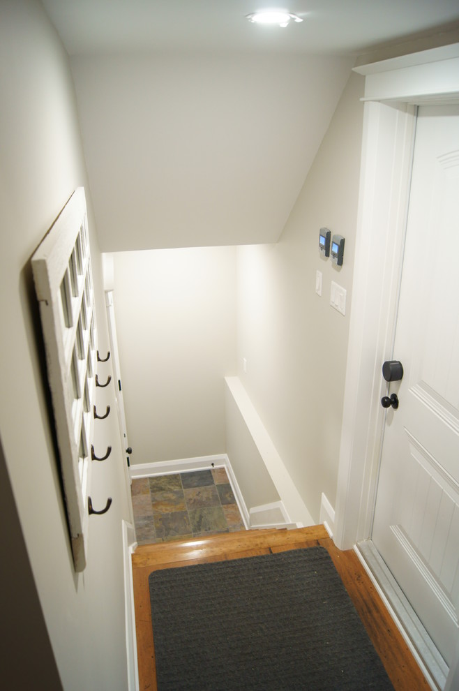 Imagen de escalera en L clásica pequeña con escalones con baldosas y contrahuellas de madera