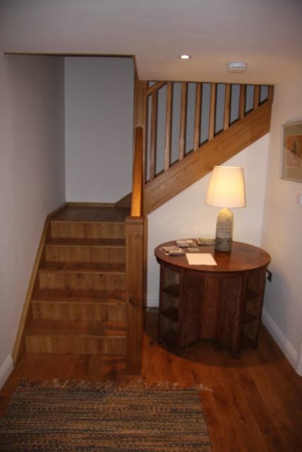 他の地域にある高級な小さなトラディショナルスタイルのおしゃれなかね折れ階段 (木の蹴込み板) の写真