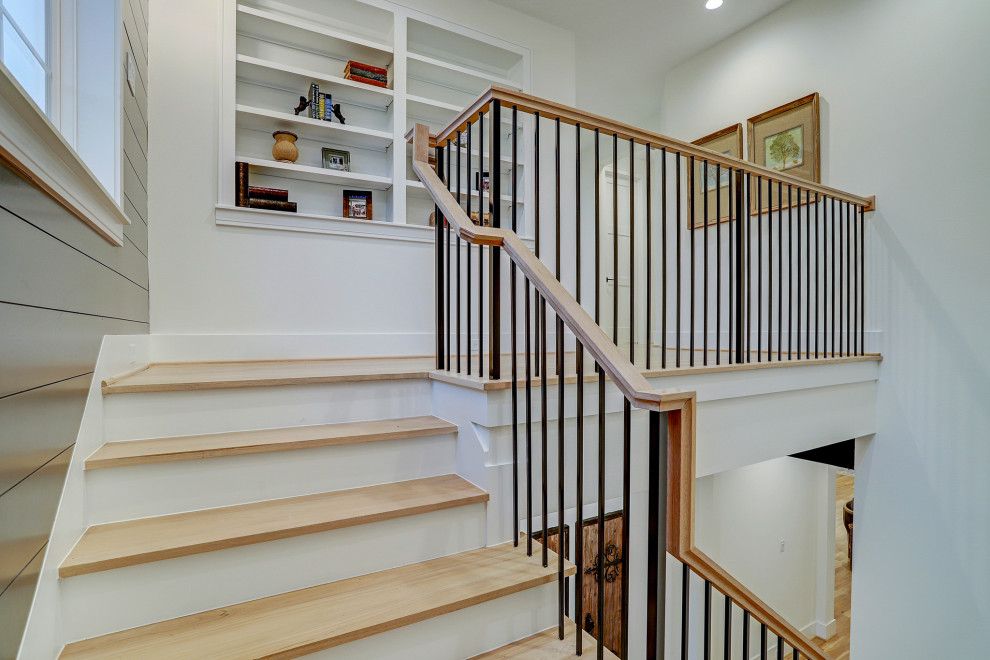 Ejemplo de escalera en U de estilo de casa de campo grande con escalones de madera, contrahuellas de madera pintada, barandilla de madera y panelado