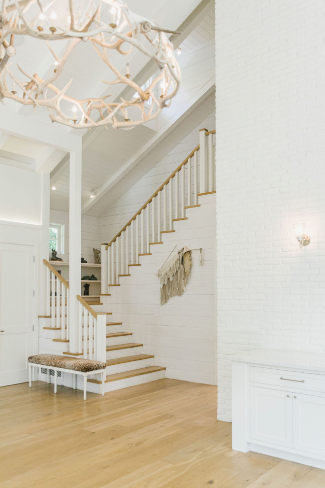 Staircase - farmhouse wooden u-shaped wood railing and shiplap wall staircase idea in Los Angeles with wooden risers