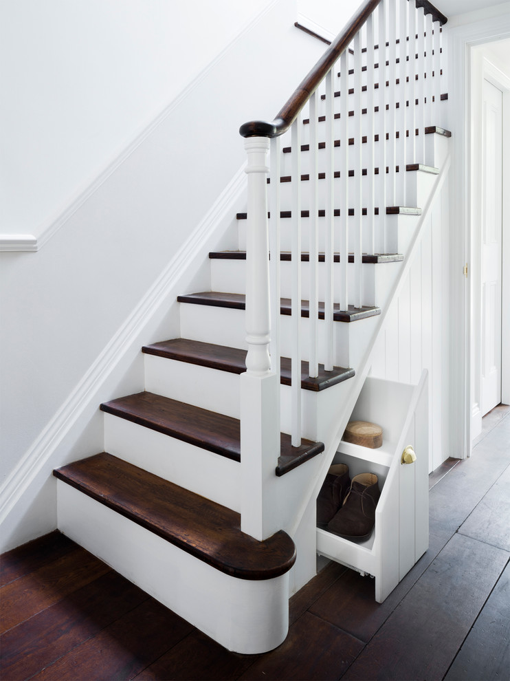 На фото: п-образная лестница среднего размера в викторианском стиле с деревянными ступенями и крашенными деревянными подступенками