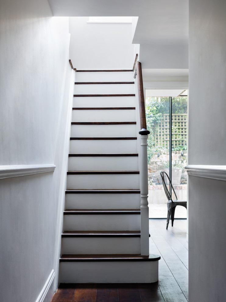 Пример оригинального дизайна: п-образная лестница среднего размера в викторианском стиле с деревянными ступенями и крашенными деревянными подступенками
