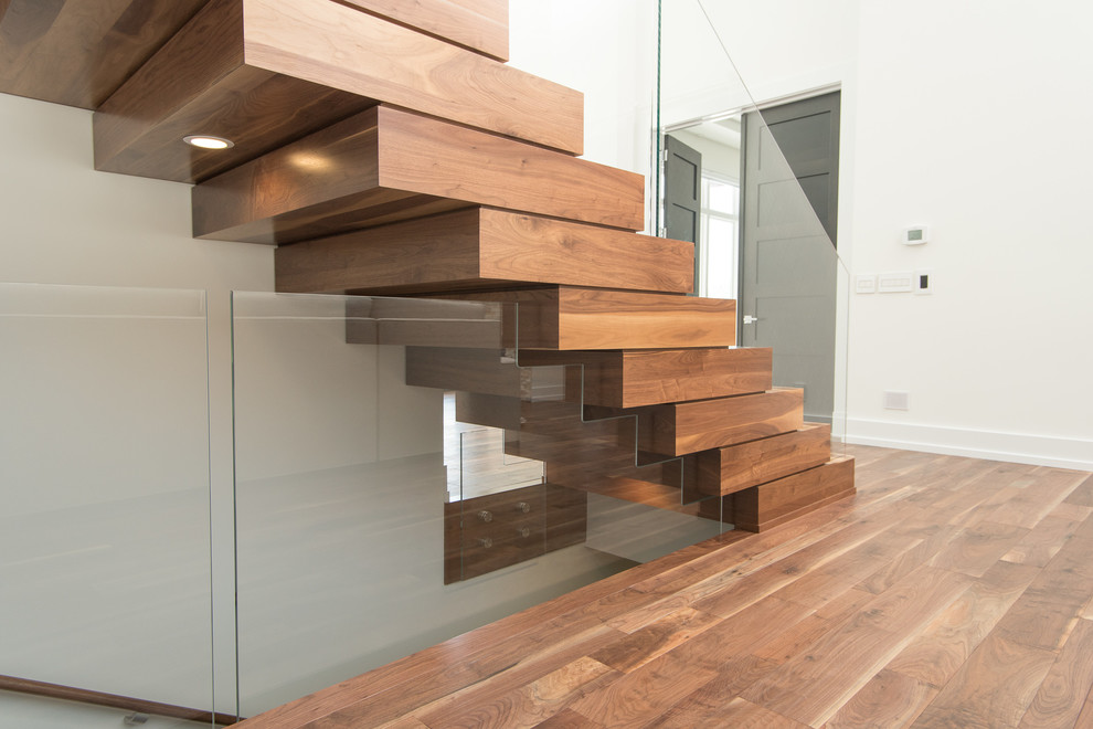 Foto di una grande scala sospesa minimalista con pedata in legno e alzata in legno