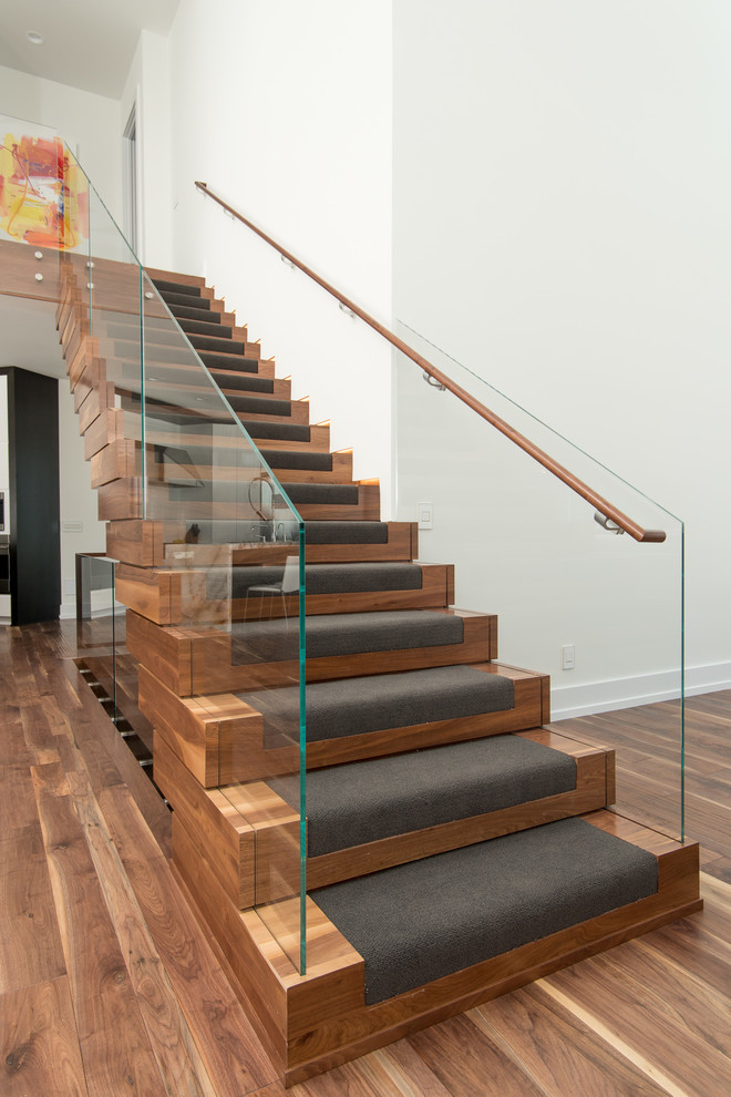Imagen de escalera suspendida moderna grande con escalones de madera y contrahuellas de madera