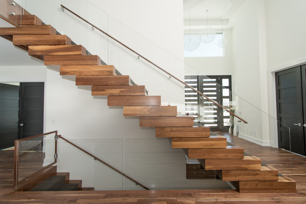 Cette photo montre un grand escalier flottant moderne avec des marches en bois et des contremarches en bois.