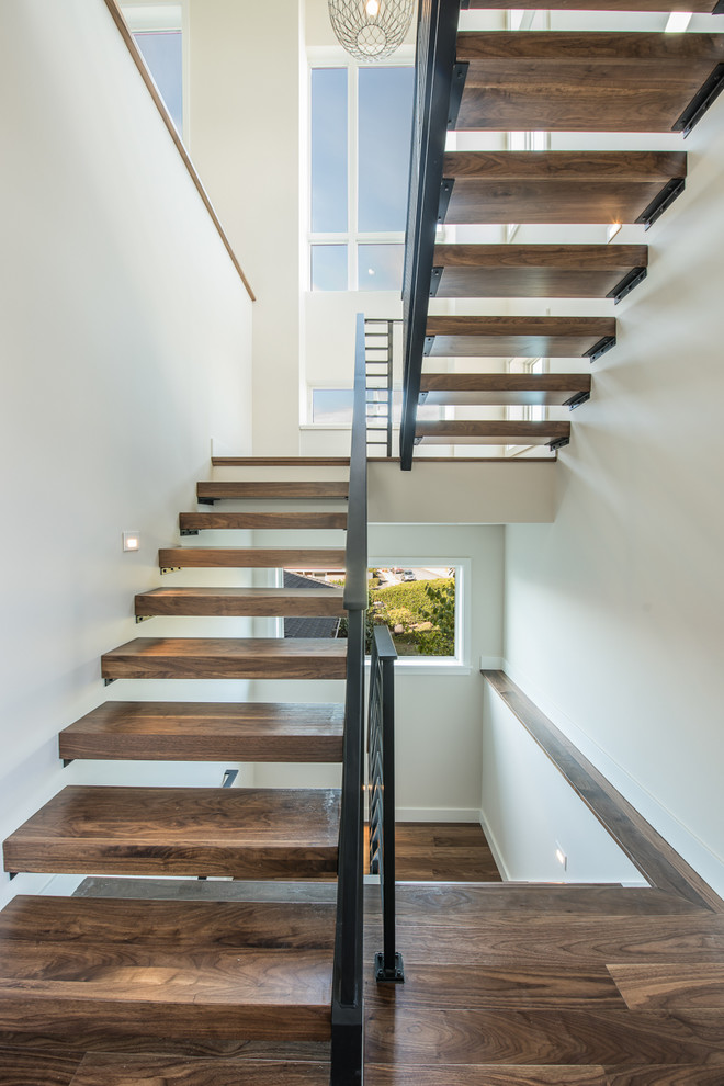 Inspiration for a medium sized modern wood u-shaped metal railing staircase in Seattle with open risers.