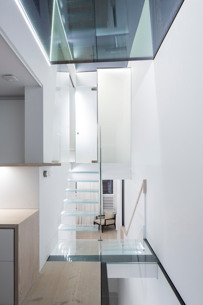 Cette photo montre un petit escalier flottant tendance avec des marches en verre et un garde-corps en bois.