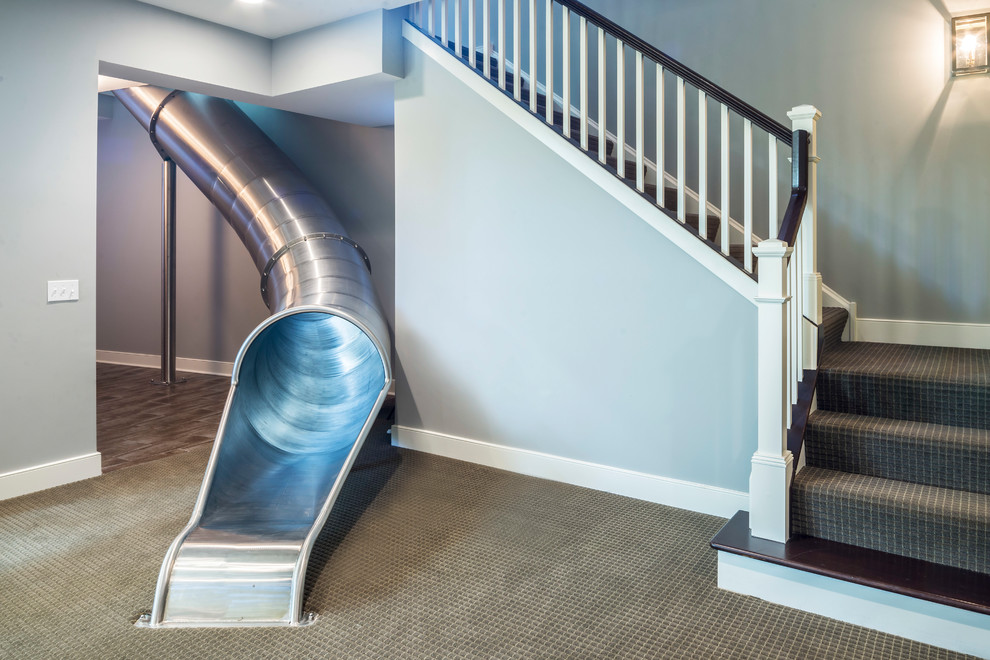 На фото: большая угловая лестница в стиле неоклассика (современная классика) с ступенями с ковровым покрытием, ковровыми подступенками и деревянными перилами