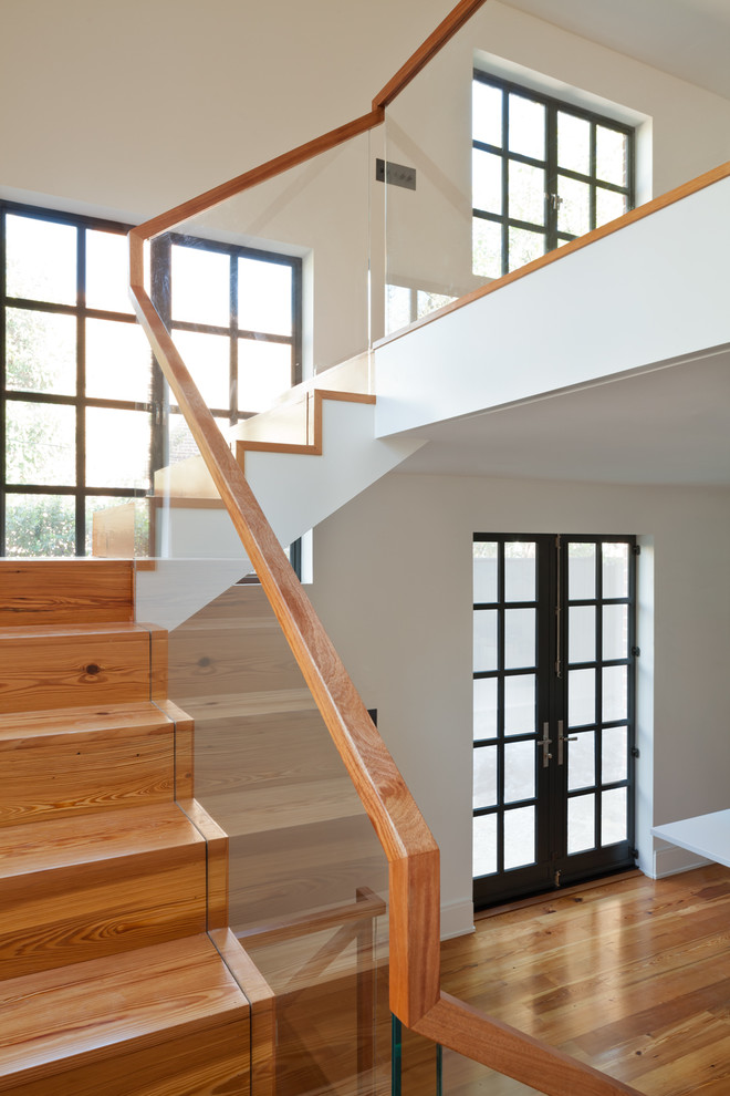 Modelo de escalera en L contemporánea de tamaño medio con escalones de madera, contrahuellas de madera y barandilla de vidrio