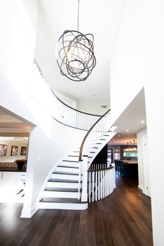 Design ideas for a large traditional wood curved wood railing staircase in Toronto with painted wood risers.