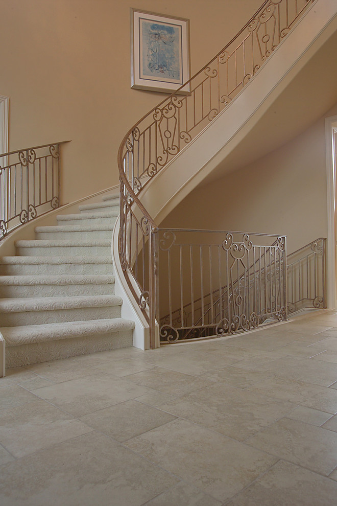 Aménagement d'un grand escalier courbe classique avec des marches en moquette et des contremarches en moquette.